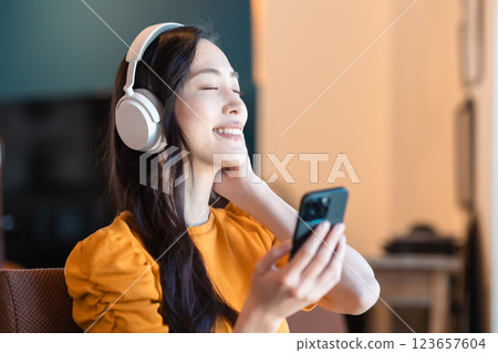一位年輕女士正在享受音樂訂閱服務 一位年輕女士正在享受音樂訂閱服務 123657604
