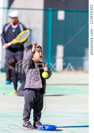 Boy playing on tennis court 123658301