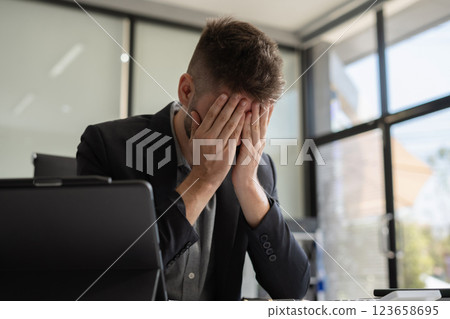 Businessman male stressed over credit card debt monthly expenses in office. 123658695