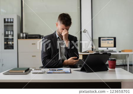 Businessman male stressed over credit card debt monthly expenses in office. 123658701