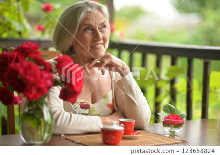 Portrait of happy aged woman drinking coffee Portrait of happy aged woman drinking coffee 123658824