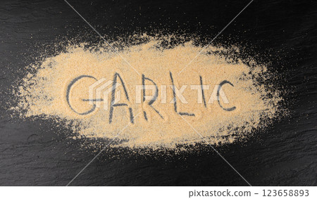 Garlic powder pile, dried granulated chopped crushed garlic cloves, cut into small pieces 123658893