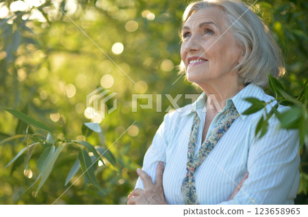 Portrait of a beautiful elderly woman in the park Portrait of a beautiful elderly woman in the park 123658965
