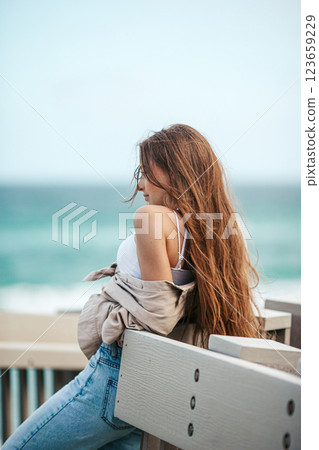 Beautiful adorable girl outdoors in the park with ocean view 123659229