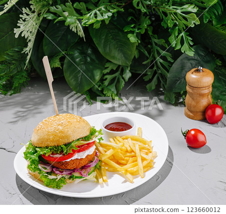 Delicious burger with fries served on a white plate Delicious burger with fries served on a white plate 123660012
