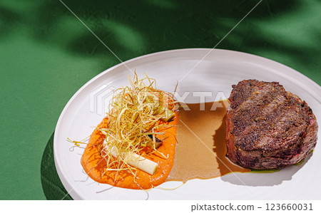 Gourmet steak dish with vibrant sides served on elegant plate Gourmet steak dish with vibrant sides served on elegant plate 123660031