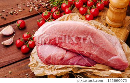 Fresh pork tenderloin surrounded by cherry tomatoes and garlic Fresh pork tenderloin surrounded by cherry tomatoes and garlic 123660073