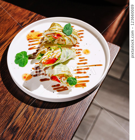 Fresh spring rolls garnished with herbs served on a plate Fresh spring rolls garnished with herbs served on a plate 123660089