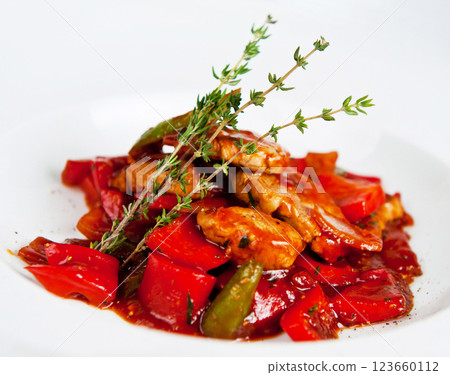 Chicken fillet with vegetables on a white plate being decorated with thyme sprigs Chicken fillet with vegetables on a white plate being decorated with thyme sprigs 123660112