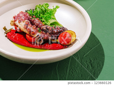 Grilled octopus dish presented with vibrant vegetables and greens Grilled octopus dish presented with vibrant vegetables and greens 123660126