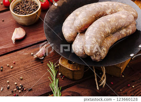 Sausages prepared with fresh herbs and spices on a wooden table Sausages prepared with fresh herbs and spices on a wooden table 123660128