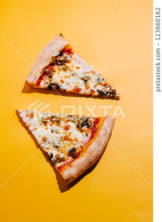 Slices of pizza on vibrant yellow background Slices of pizza on vibrant yellow background 123660162