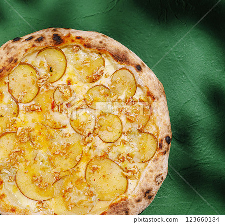 Unique potato pizza on a green surface with toppings Unique potato pizza on a green surface with toppings 123660184