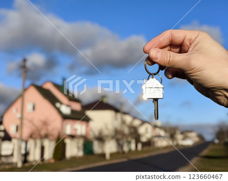 The concept of buying an apartment. Man holds the keys to the house in his hands against the backdrop of residential buildings. Concept for buying and renting apartments The concept of buying an apartment. Man holds the keys to the house in his hands against the backdrop of residential buildings. Concept for buying and renting apartments 123660467