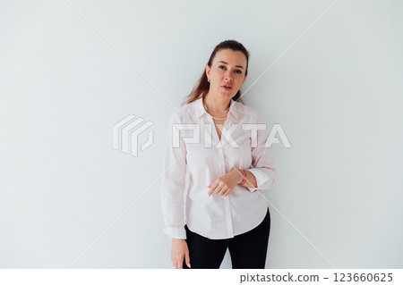 Portrait of a beautiful woman of 40 years old in a business suit near a white wall 123660625