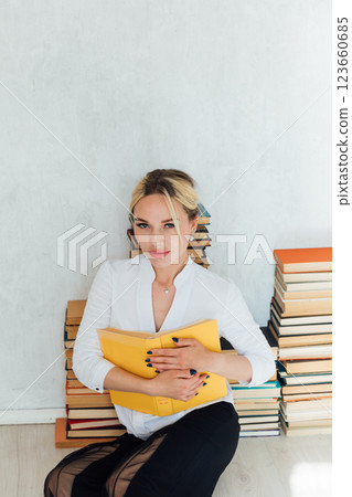 woman teacher and piles of university educational books 123660685