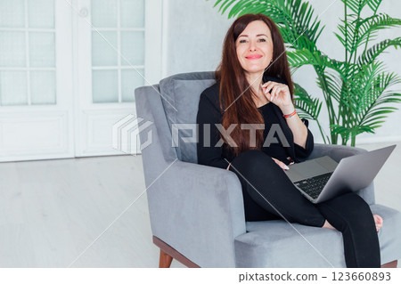 woman brunette sitting on chair online laptop woman brunette sitting on chair online laptop 123660893