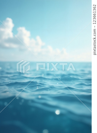 blue surface of ocean water close up, low angle, against background of sky and white clouds, impressive seascape, beautiful and calm water surface 123661362
