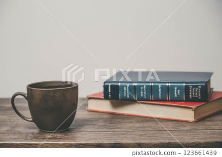A mug and a book on a wooden desk 123661439