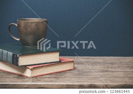 木桌上的一個杯子和一本書 123661445
