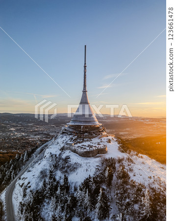 Breathtaking view of Jested Mountain adorned with fresh snow as the sun rises, illuminating the peaks and creating a serene winter landscape. Nature awakens in the early morning light. Breathtaking view of Jested Mountain adorned with fresh snow as the sun rises, illuminating the peaks and creating a serene winter landscape. Nature awakens in the early morning light. 123661478