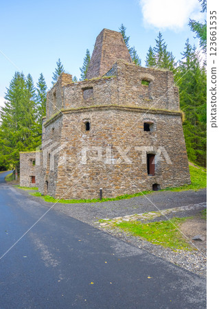 The former lime kiln near Kovarska is a stone structure set against a backdrop of green pine trees. It stands as a relic of industrial history in Czechia, merging nature and heritage. The former lime kiln near Kovarska is a stone structure set against a backdrop of green pine trees. It stands as a relic of industrial history in Czechia, merging nature and heritage. 123661535