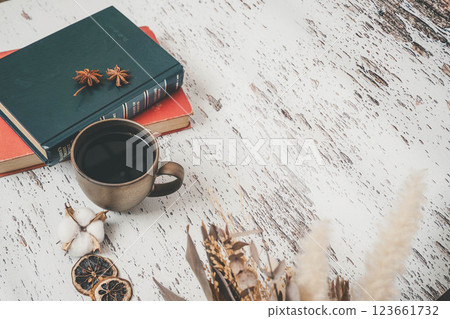 A mug and a book on a wooden desk 123661732