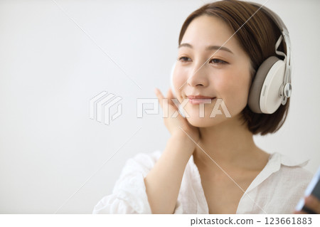 戴耳機聽音樂的年輕女子 戴耳機聽音樂的年輕女子 123661883