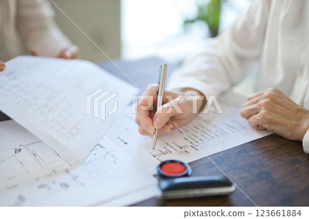 The hands of two women signing a real estate contract 123661884