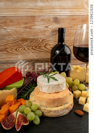 Cheese plate of color cheeses variety, yellow, white and blue gorgonzola platter with red wine glass 123661926