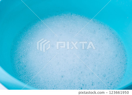 Hand laundry washing clothes in blue plastic basin Hand laundry washing clothes in blue plastic basin 123661950