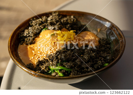Vegetarian spinach salad closeup. Fried spinach with nori and tahini, vegan dish in sunlight Vegetarian spinach salad closeup. Fried spinach with nori and tahini, vegan dish in sunlight 123662122