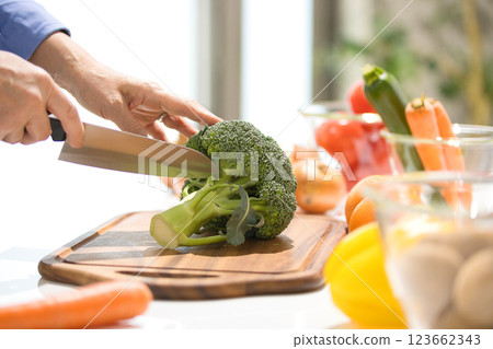 Hands of a middle-aged woman cutting vegetables 123662343