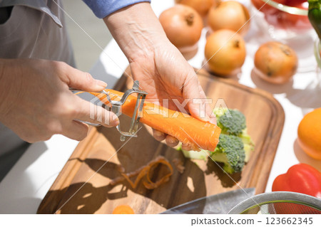 Hands of a middle-aged woman cutting vegetables 123662345