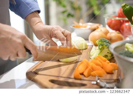 Hands of a middle-aged woman cutting vegetables Hands of a middle-aged woman cutting vegetables 123662347