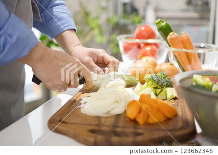 Hands of a middle-aged woman cutting vegetables 123662348