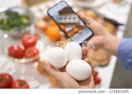 The hands of a middle-aged woman taking pictures of cooking ingredients with her smartphone 123662695