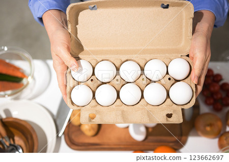 Middle-aged woman's hand holding fresh eggs 123662697