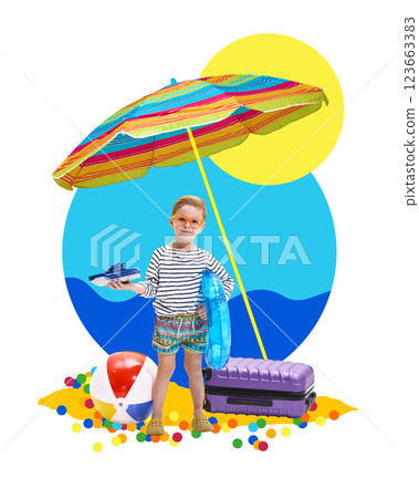 Happy boy holding toy boat, standing under colorful umbrella with beach ball and suitcase. Seaside adventure. 123663383