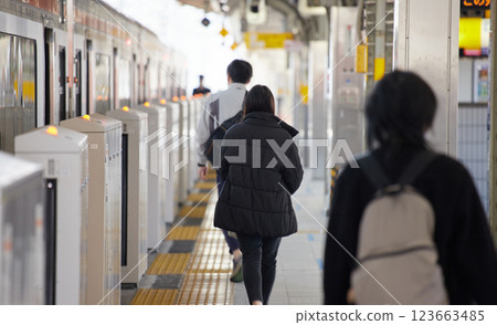 People waiting for a train on a station platform on a winter morning People waiting for a train on a station platform on a winter morning 123663485