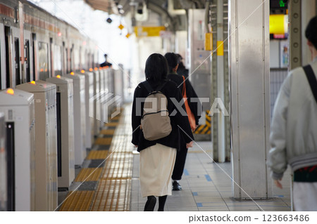 冬日早晨,一名年輕女子在月台上等火車 冬日早晨,一名年輕女子在月台上等火車 123663486