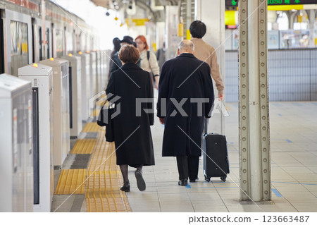 Senior couple walking on the station platform on a winter morning Senior couple walking on the station platform on a winter morning 123663487