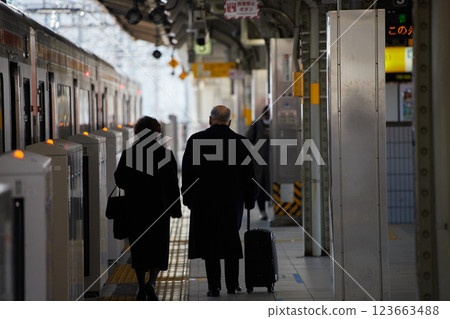 Senior couple walking on the station platform on a winter morning Senior couple walking on the station platform on a winter morning 123663488