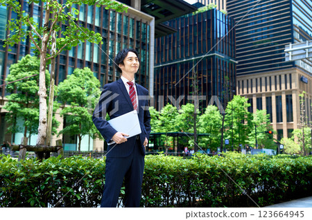 Businessman standing with a laptop in an office building 123664945