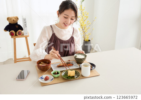 A woman looking at her smartphone at breakfast A woman looking at her smartphone at breakfast 123665972