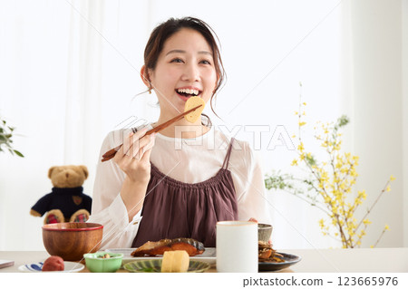 A woman looking at her smartphone at breakfast 123665976