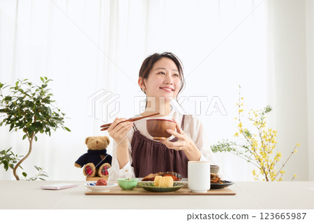 一位女士在吃早餐時看著她的智慧型手機 123665987