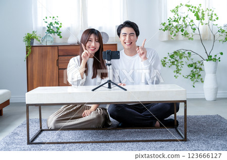 Men and women pointing their fingers at a video Men and women pointing their fingers at a video 123666127