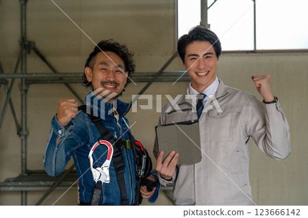 A man doing a guts pose in work clothes A man doing a guts pose in work clothes 123666142