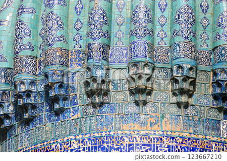 Turquoise Islamic Tile on Blue Dome with arabic calligraphy, geometric and floral patterns on sunny day. Traditional middle eastern architecture with vibrant blue and azure hues on patina 123667210